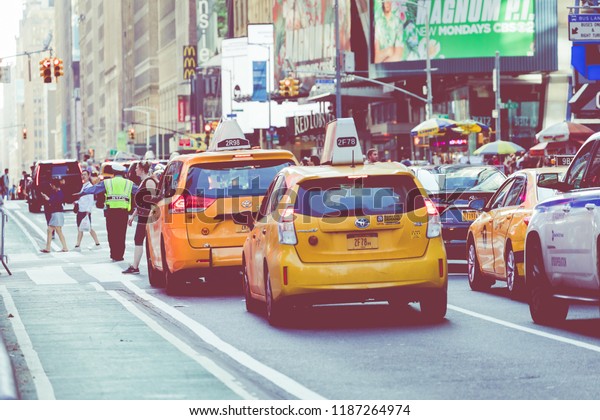 NEW YORK - SEPTEMBER\
2, 2018: Yellow cab speeds through Times Square the busy tourist\
intersection of neon art and commerce and is an iconic street of\
New York City, USA.