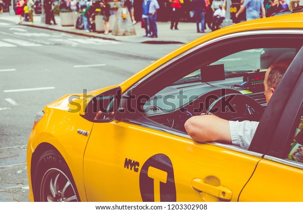 NEW YORK - SEPTEMBER\
2, 2018: Yellow cab speeds through Times Square the busy tourist\
intersection of neon art and commerce and is an iconic street of\
New York City, USA