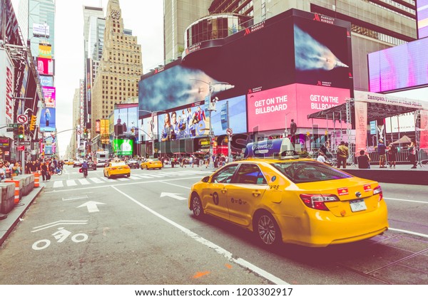 NEW YORK - SEPTEMBER\
2, 2018: Yellow cab speeds through Times Square the busy tourist\
intersection of neon art and commerce and is an iconic street of\
New York City, USA