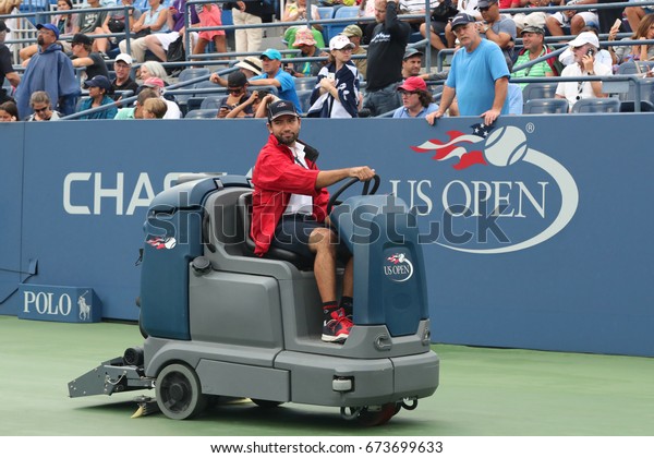 NEW YORK - SEPTEMBER\
6, 2016: US Open cleaning crew drying tennis court after rain delay\
at Louis Armstrong Stadium at Billie Jean King National Tennis\
Center in New York