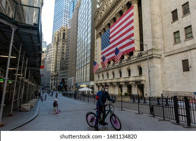 New York Stock Exchange After The Coronavirus Outbreak With Person On Bike With A Mask In Foreground At 11 Wall Street, New York, NY, USA On March 21, 2020