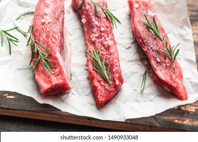 New York Strip Steak With Salt And Rosemary On Black Background, Top View, Close Up. Uncooked Raw Beef Strip Steaks.