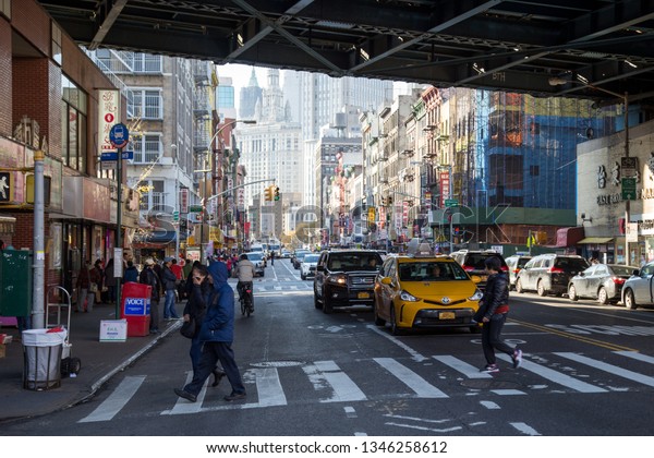 New\
York, United States of America - November 11, 2016: People on the\
street at the Manhattan Bridge in Chinatown\
district.