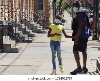 New York, New York / United States - May 3 2020: Man And Child Wearing Face Masks Walking On Sidewalk During Coronavirus Pandemic