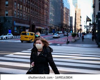 New York, United States, USA March 24, 2020: Woman With Mask Walking In Nearly Empty New York Street During Covid 19 Pandemic Outbreak