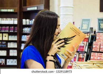 New York, New York, USA 08 03 2016: Beautiful Latin Teenager Smiling And  Smelling A New Book  For World Book Day At A Bookstore