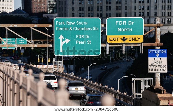 New\
York, USA - 2021: Traffic signs at the entrance to Manhattan from\
Brooklyn Bridge indicating the main streets an\
exits