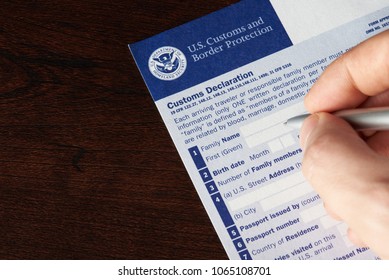 New York, USA - April 9, 2018: Filling Up Us Customs Declaration Form On Wooden Table Above View