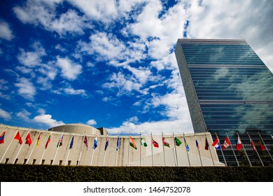 New York/ USA - August 2 2017: Outside The United Nations Headquarters, A Tourist Stands In Front And A View Of Objects Inside.