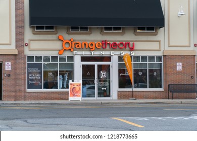 New York, USA - Circa 2018: Orange Theory Fitness Exterior Gym Studio Store Front Franchise Facade And Sign. View From Parking Lot. Heart Rate Interval Group Training Concept