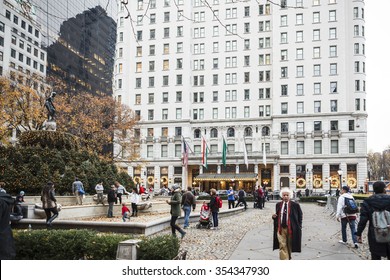 New York, New York, USA - December 11, 2015: Grand Army Plaza And The Plaza Hotel In Manhattan. People Can Be Seen On Grand Army Plaza. Wreaths  On Plaza Hotel Windows Reflect The Christmas Season.