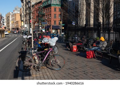 New York, New York USA - December 28 2020: Row Of Food Delivery Men And Delivery Bikes Waiting At A Park In Nolita Of New York City