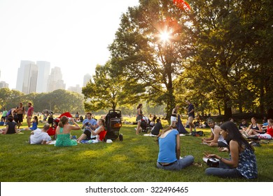 New York, New York, USA - July 10, 2011: People Enjoying A Beautiful Summer Day In Sheep Meadow, Central Park. The Sun Shines Through The Trees In The Late Afternoon.