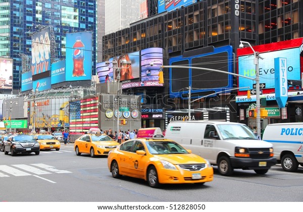 NEW YORK, USA - JULY 2, 2013: Taxis drive along\
Times Square in New York. Times Square is one of most recognized\
landmarks in the world. More than 300,000 people pass through Times\
Square daily.