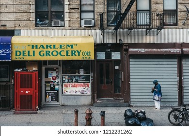 New York, USA - June 01, 2018: Woman Standing On A Street Next To A Deli In Harlem, NYC. Since The 1920s, Harlem Has Been Known As A Major African American Residential, Cultural And Business Center. 