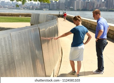 New York, USA - June 09, 2018: People Look On The American Immigrant Wall Of Honor Is Located At The Ellis Island National Museum. 