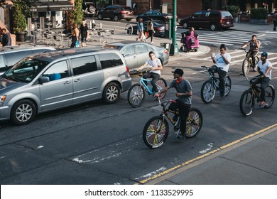 New York, USA - June 1, 2018: Teenagers Riding Bikes On The Road In Harlem, New York. Since The 1920s, Harlem Has Been Known As A Major African American Residential, Cultural And Business Center. 