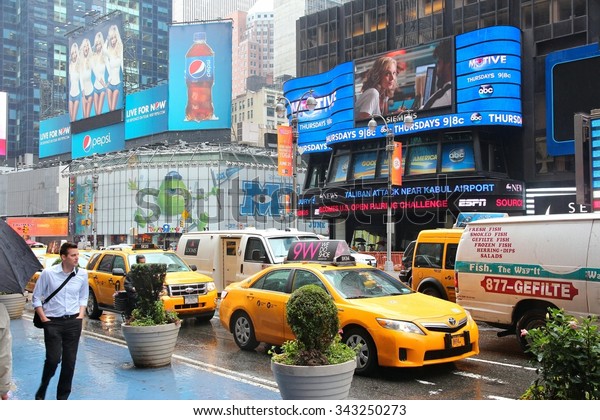 NEW YORK, USA - JUNE 10, 2013: Taxis drive along\
Times Square in New York. Times Square is one of most recognized\
landmarks in the world. More than 300,000 people pass through Times\
Square daily.