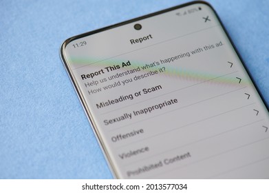 New york, USA - June 28 2021: Reporting scam ads in facebook  on smartphone screen close up
