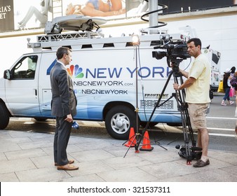 New York, New York, USA - June 29, 2015: An NBC TV Reporter And His Camera Man In Herald Square In Manhattan. The Are Standing In Front Of An NBC Broadcast Van. Others Can Be Seen In The Background.