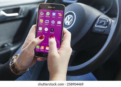 New York, USA - March 08, 2015: Woman Using Her Black Samsung S5 Smart Phone Phone In The Car.