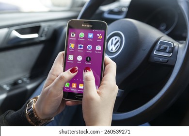 New York, USA - March 08, 2015: Woman Using Her Black Samsung S5 Smart Phone In The Car.