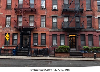 New York, New York USA March 17 2022: Old Red Brick Apartment Buildings With Fire Escapes Along A Street In Hell's Kitchen Of New York City