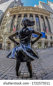 NEW YORK, USA - MARCH 9, 2020: Facade of the New York Stock Exchange on Wall Street, Manhattan with Fearless Girl in front, a bronze sculpture by Kristen Visbal.