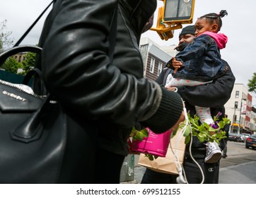NEW YORK, USA - May 05, 2016: Manhattan street scene. New Yorkers in Manhattan in a hurry about their business. A young African American family with a child in the streets of a big city