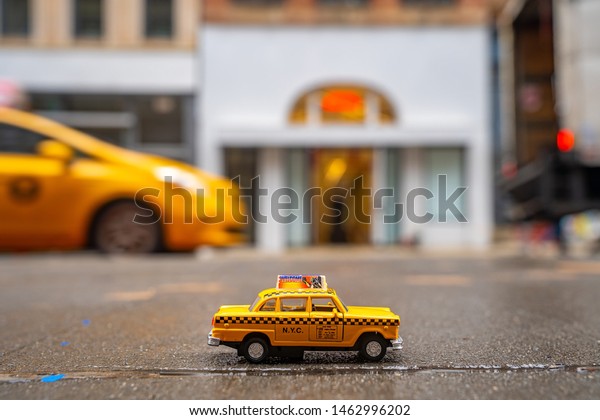 New\
York, USA. May 10, 2019. Vintage old Taxi toy in New York City most\
popular places. Classic Yellow Cab in Manhattan and Brooklyn. The\
symbol of New York. Driving a taxi through Brooklyn.\
