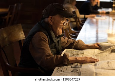 New York, USA - May 2019 - Old Man Reading Newspaper At The New York Public Library On Fifth Avenue In Manhattan.