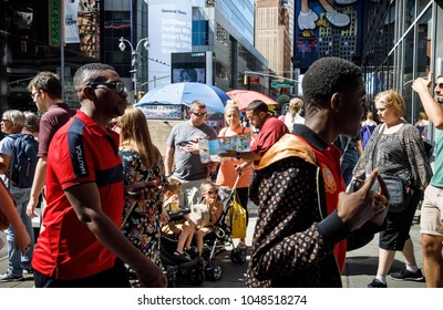 NEW YORK, USA - Sep 23, 2017: Manhattan street scene. New Yorkers and tourists in a hurry about their business and relaxing on Times Square. Group of young parents with children in wheelchairs
