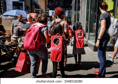 NEW YORK, USA - Sep 23, 2017: Manhattan street scene. New Yorkers and tourists in a hurry about their business, walking and relaxing on Times Square in NYC. Women with children and backpacks for dolls