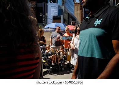 NEW YORK, USA - Sep 23, 2017: Manhattan street scene. New Yorkers and tourists in a hurry about their business and relaxing on Times Square. Group of young parents with children in wheelchairs