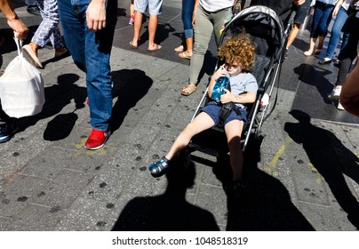NEW YORK, USA - Sep 23, 2017: Manhattan street scene. New Yorkers and tourists in a hurry about their business, walking and relaxing on Times Square in NYC. A child in a stroller drinks water