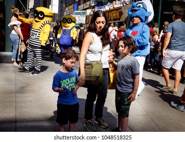 NEW YORK, USA - Sep 23, 2017: Manhattan Street Scene. New Yorkers And Tourists In A Hurry About Their Business, Walking And Relaxing On Times Square. Mother With Two Boys And Heroes Of Cartoon Films