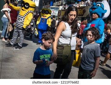 NEW YORK, USA - Sep 23, 2017: Manhattan street scene. New Yorkers and tourists in a hurry about their business. Mother with two children walking and relaxing on Times Square in NYC