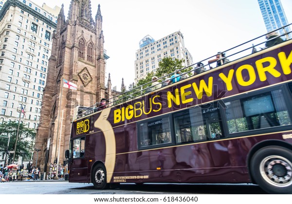 New York,\
USA - SEPTEMBER 17, 2017: Trinity Church in Lower Manhattan and\
street with tourists and traffic New York USA. It is a historic\
parish church near Wall Street and\
Broadway.