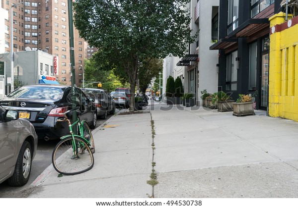 New York, USA\
- September 21, 2015: Forgotten and broken bike is attached to a\
pole at the edge of the\
road