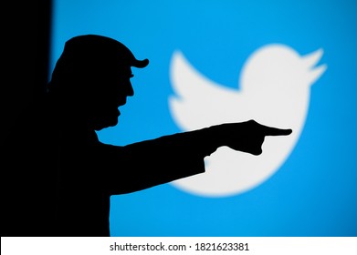 NEW YORK, USA, SEPTEMBER 25, 2020: Donald Trump versus Twitter. Silhouette of angry American President in conflict with Chinese social network Twitter. Logo of company on blue screen in background