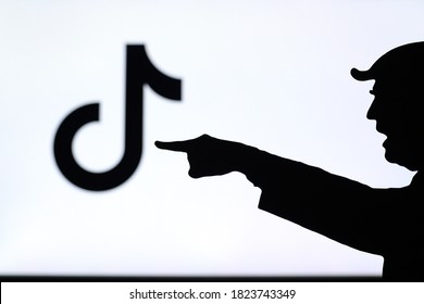 NEW YORK, USA, SEPTEMBER 25, 2020: Donald Trump versus Tik Tok. Silhouette of American President in conflict with Chinese social network TikTok. Logo of company on screen in background. China vs USA.