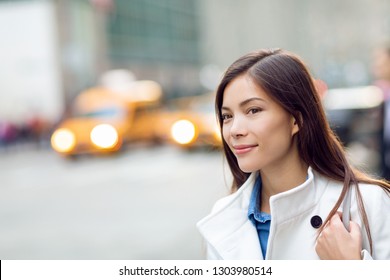 New Yorker Woman Walking On New York City Street Waiting For Car Lift Rideshare Taxi. Asian Young Professional With Yellow Taxi Cabs Cars Traffic In Background. Biracial Person.