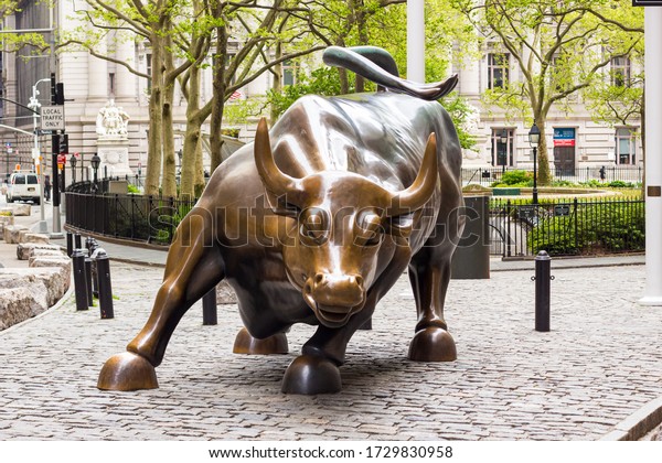 New York/New\
York/United States - 05-11-2020: Wall Street bull in Manhattan New\
York City with no people around when the United States faces the\
corona virus pandemic