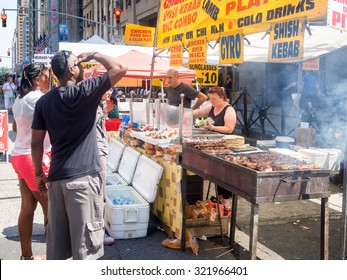 NEW YORK,USA - AUGUST 15,2015 : Street kiosk selling ethnic food at a street fair next to the Rockefeller Center in Manhattan