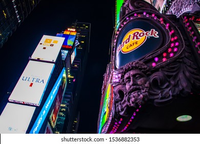 New York/USA - January 5, 2018: Closeup Of Hard Rock Cafe Facade During Evening With Times Square Animated Led Signs As Blurred Background