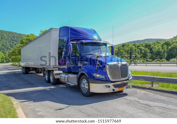 New York,USA-June 16,2018:The blue truck\
and white container Stop on the high\
way.