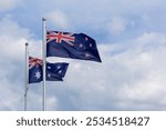 New Zealand and Australia national flags flying side by side against blue sky background