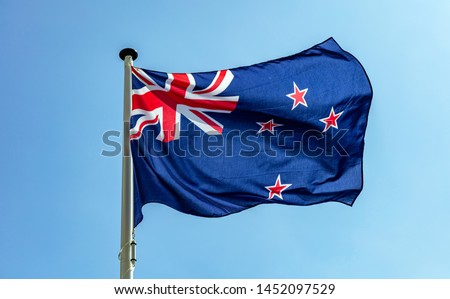 New Zealand flag, New Zealand national symbol waving against clear blue sky, sunny day