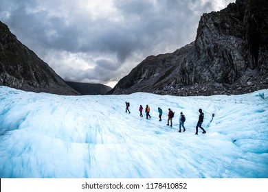 NEW ZEALAND, FOX GLACIER - MAY 2016: Hikers and travelers walking on ice in Fox Glacier, New Zealand. Breathtaking guided glacier walk onto the world-famous Fox Glacier.