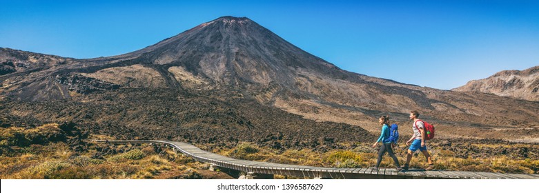 New Zealand Hiking Couple Backpackers Tramping At Tongariro National Park. Two Hikers Hiking By Mount Ngauruhoe. People Living Healthy Active Lifestyle Outdoor Panoramic Banner.